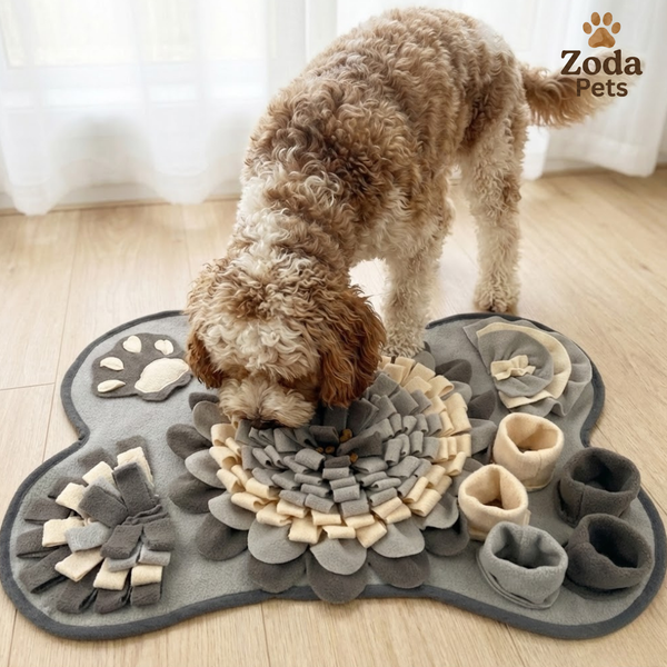 Dog playing with a gray and beige snuffle mat on a wooden floor.